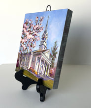 Load image into Gallery viewer, Original oil painting titled Greenbrier Chapel in Spring by Pat Cross. The painting rests on a black display easel.