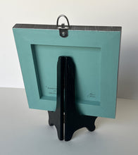Load image into Gallery viewer, Back view of Original oil painting titled Greenbrier Chapel in Spring by Pat Cross. The painting rests on a black display easel.