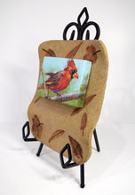 Load image into Gallery viewer, Forest Ruby Cardinal original painting by Pat Cross mounted on a hand built and kiln fired stoneware frame resting on a black metal easel facing left.
