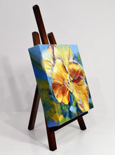 Load image into Gallery viewer, Sunny Petunia original oil painting on display easel facing right by Pat Cross.
