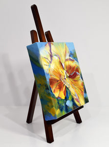 Sunny Petunia original oil painting on display easel facing right by Pat Cross.